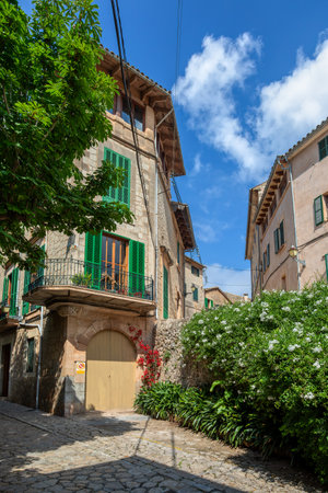 Narrow street in the Valldemossa with lots of ubiquitous flowers. Architectural treasures - Magic of Valldemossa's historic center and its Mediterranean architecture. Balearic Islands Mallorca Spain.のeditorial素材
