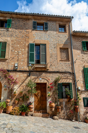Narrow street in the Valldemossa with lots of ubiquitous flowers. Architectural treasures - Magic of Valldemossa's historic center and its Mediterranean architecture. Balearic Islands Mallorca Spain.のeditorial素材