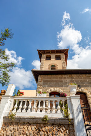 Narrow street in the Valldemossa with lots of ubiquitous flowers. Architectural treasures - Magic of Valldemossa's historic center and its Mediterranean architecture. Balearic Islands Mallorca Spain.のeditorial素材