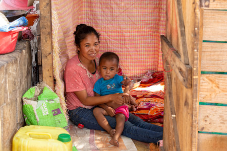 Miandrivazo, Madagascar - November 2, 2022: Young mother with their children in front of their house.のeditorial素材