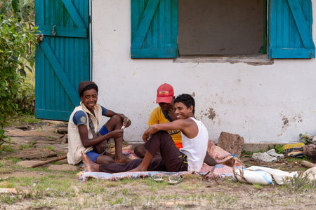 Andringitra, Madagascar - November 16th, 2022: Young Malagasy men resting in the shade of a house and playing cards.のeditorial素材
