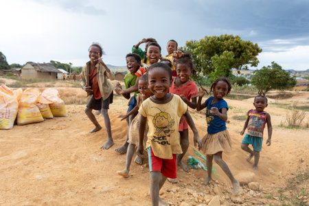 Ilakaka, Madagascar - November 24, 2022: Curious group of children looking at a tourist near the gem...