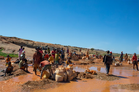 Ihosy, Ilakaka, Madagascar - November 20, 2022: Local people mine for gems and pan for gold in a river. The town is a major center of sapphire production and trade.のeditorial素材