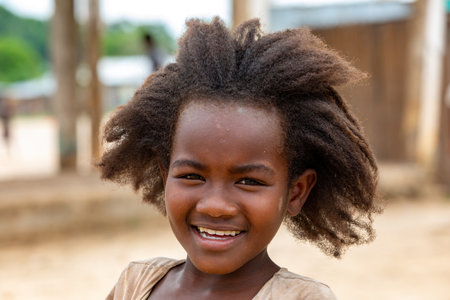 Bekopaka - Antsalova, Madagascar- November 6, 2022: Small cute Malagasy girl with long hair, happy little dancer on celebration in village Bekopaka, region of Melaky, Madagascar.のeditorial素材
