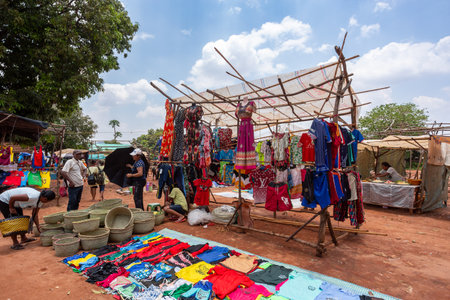 Mandoto, Madagascar - November 9th, 2022: A bustling street market in Mandoto city with vendors selling various types of clothes with vibrant colors.のeditorial素材
