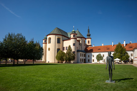 Gothic medieval church, Piarist Church of the Finding of the Holy Cross at sunny summer day, Monastery Garden with sculptures, Litomysl, Czech Republicの写真素材