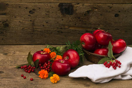 red apples in a basket on a wooden backgroundの写真素材