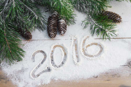 Pine branches with cones in the snow with the inscription 2016の写真素材