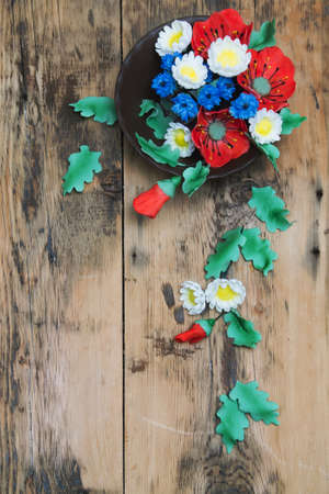 sugar poppies, daisies and blue flowers on a wooden background. Toned photoの写真素材