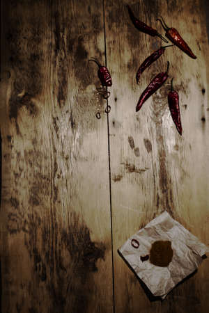 dried red chilli and ground pepper on a wooden background. Tinted darkened photoの写真素材