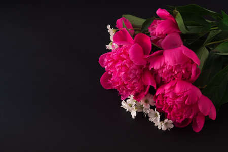 bouquet of pink peony and small white flowers closeup on dark textural background. top viewの写真素材