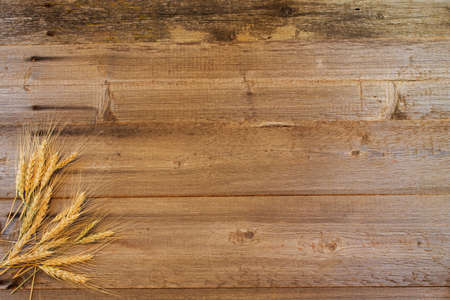 wooden background with ripe ears of wheatの写真素材