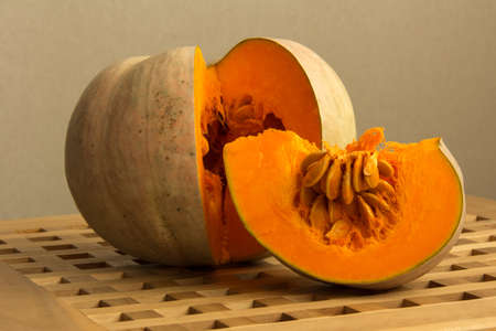 pumpkin cut in half on a wooden table, close-up