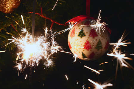 Sparkler burning on a Christmas tree.Christmas tree decoration and sparkler close-up