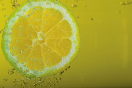 Lemon with drops in yello water