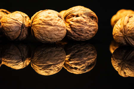 Walnuts on a dark reflective table. . Black backgroundの写真素材