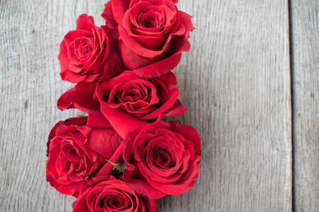 Red roses in a rustic background. Roses on a gray wooden backgroundの写真素材