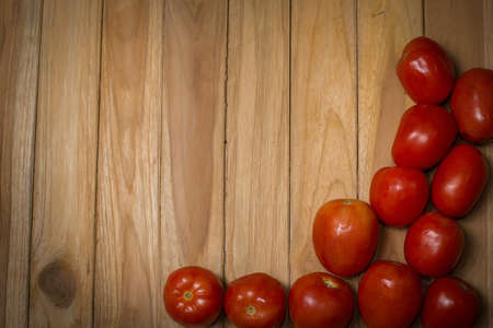 tomato on wooden background with space for textの写真素材
