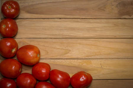 tomato on wooden background with space for textの写真素材