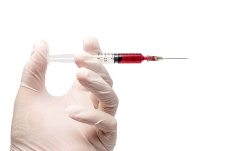 hand hold syringe with blood on white backgroundの写真素材