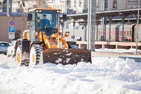 Wheel loader cleaning a road from snow in Russia