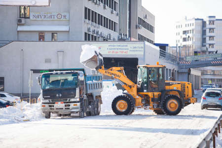 Wheel loader cleaning a road from snow in Russia