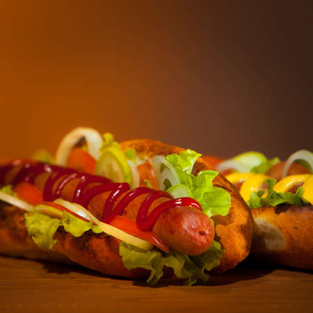 Two teasty hot dogs on lies on wood table on warm backgroundの写真素材