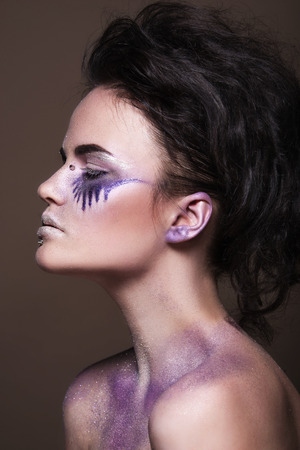 Fashion model with colorful make-up and blue glitter and sparkles on her face and bodyの写真素材