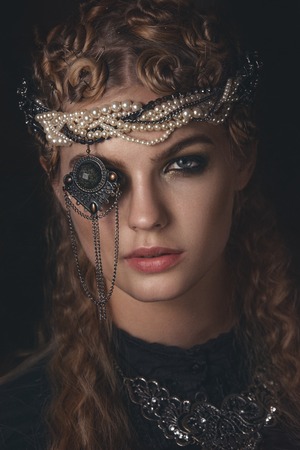 Queen of darkness in black fantasy costume on dark gothic background. High fashion beauty model with...