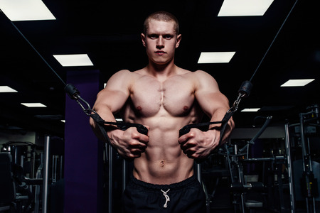Brutal strong athletic man pumping up muscles. Muscular bodybuilder with naked sport torso doing...