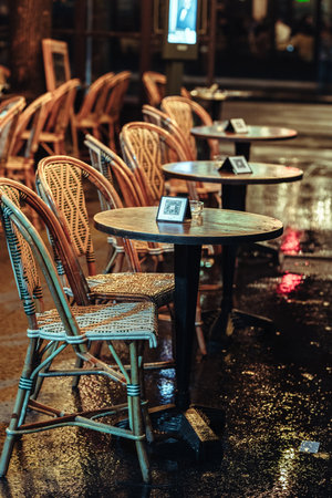 Tables and chairs of a Parisian street cafe in the rainの写真素材