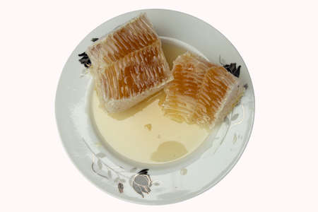 Pure honey in the plate on isolated white Backgroundの写真素材
