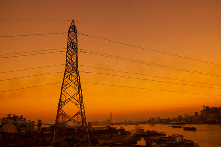 High Voltage electric pylons with colorful landscapes after sunsetの写真素材
