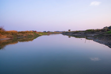 Arial View Canal with green grass and vegetation reflected in the water nearby Padma river in...