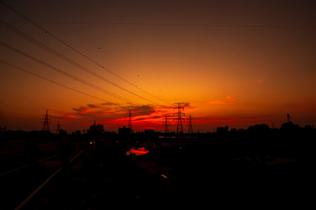 High Voltage electric pylons silhouette with colorful landscapes after sunset