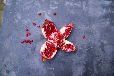 Ripe pomegranate fruit cut in half on dark background