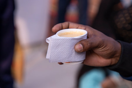 Closeup of a man's hand holding a cup of coffee.