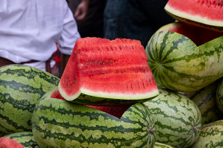 Ripe red a slice of watermelon with many watermelons are sold in the Market in the summer heatの写真素材