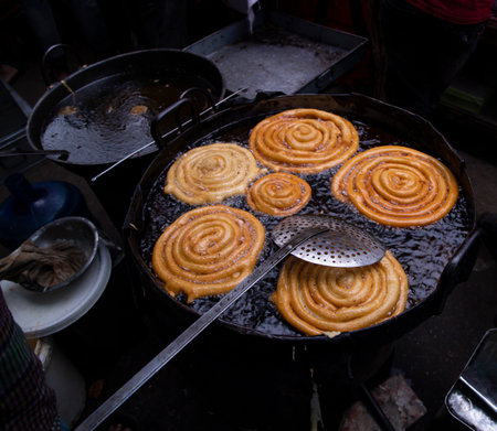 Delicious Testy sweet  jalebi fried in the cooking pan on a street food market in Chakbazar, Dhaka-Bangladeshの写真素材