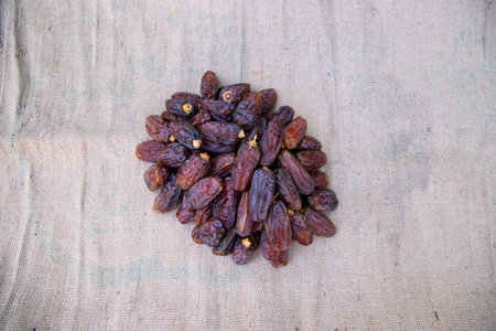 Some delicious Date fruits on the brown jute fiber fabric to eat during Ramadan Karim fasting