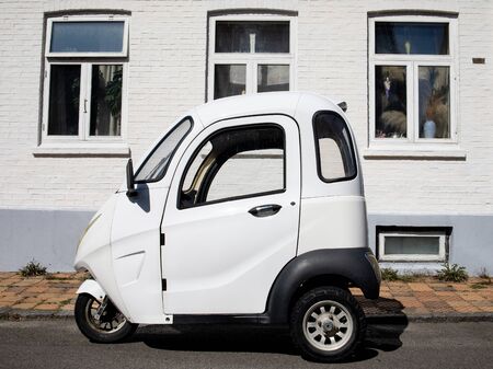 small white electric car on a white house background, Ronne, Bornholmの写真素材