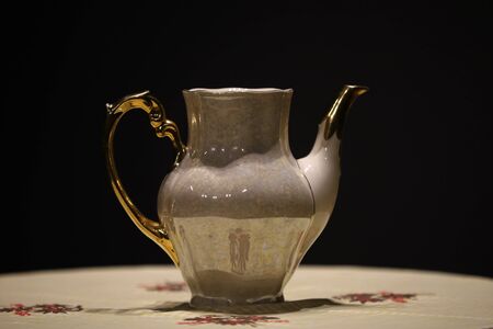 stylish porcelain tea pot against black backgroundの写真素材