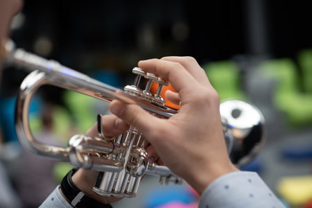 Close up of the hands of a young woman playing the trumpet.