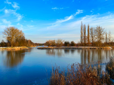 Beautiful winter landscape with frozen lake and blue sky with white clouds. Nieporet, Polandの写真素材