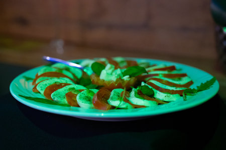 canape with mozzarella cheese and tomato on a green plateの写真素材