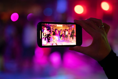 Woman taking photo on smart phone in night club, close-upの写真素材