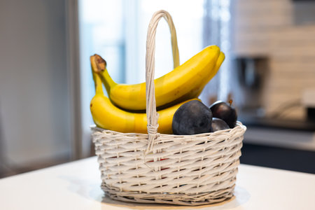Basket of bananas and blueberries on the table in the kitchenの写真素材