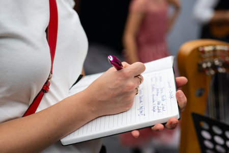 Close-up of a woman's hand writing on a notepadの写真素材