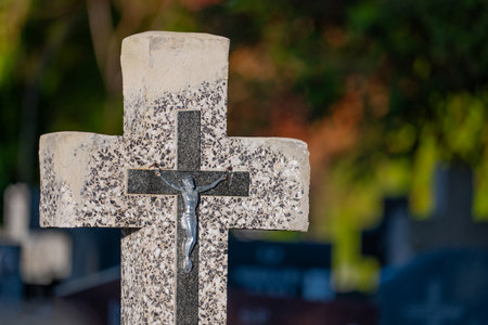 Cross in a cemetery with blurred background, shallow depth of field.の写真素材