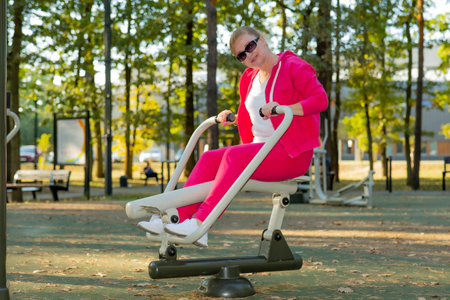 Woman exercising on a elliptical trainer machine in the park.の写真素材